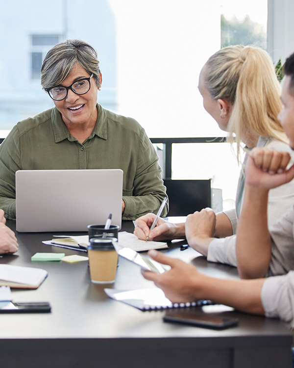 Middle aged woman with glasses speaking during a business meeting
