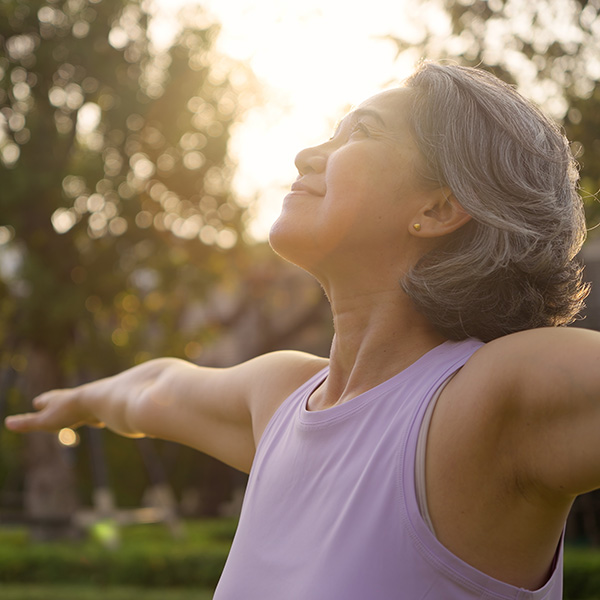 Older woman practicing yoga outside