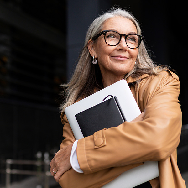 Smiling business woman with glasses holding notebooks